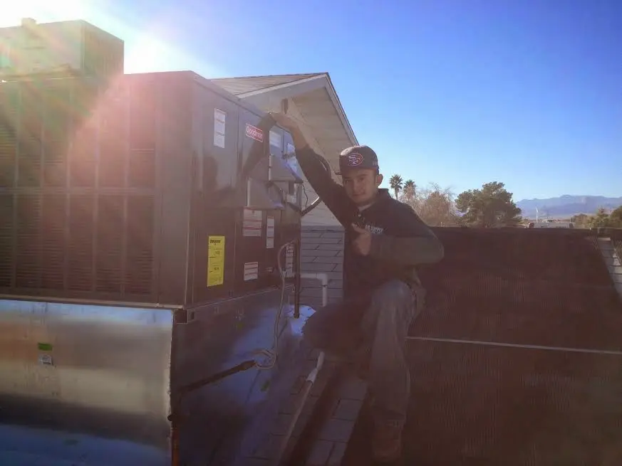 HVAC technician performing Boiler Repair on a rooftop unit in Arnold